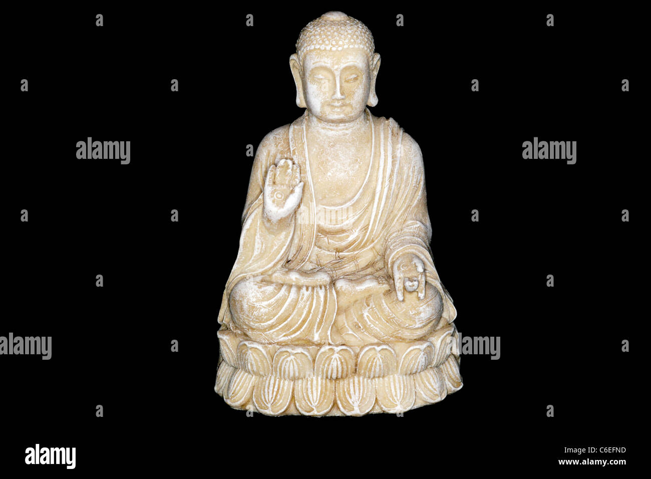 Statue of Buddha meditating on lotus flower against black background Stock Photo