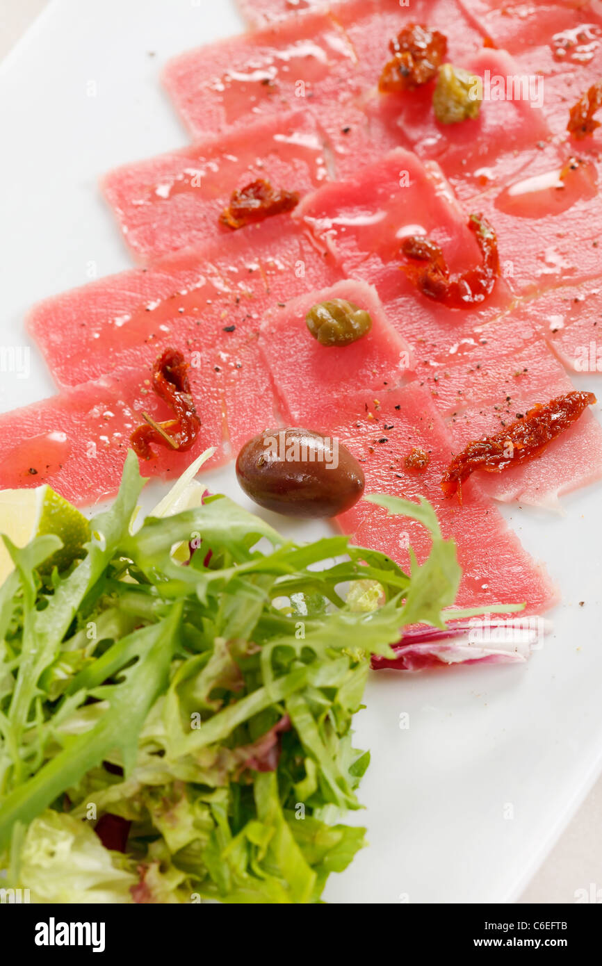 Fish Carpaccio with olives and salad Stock Photo Alamy