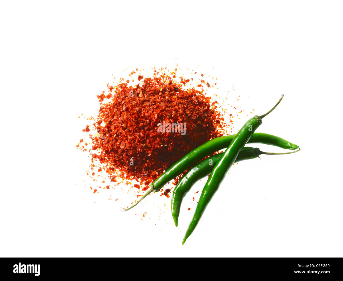Studio shot of Red Chili Powder and Whole Green Chilies on white background Stock Photo