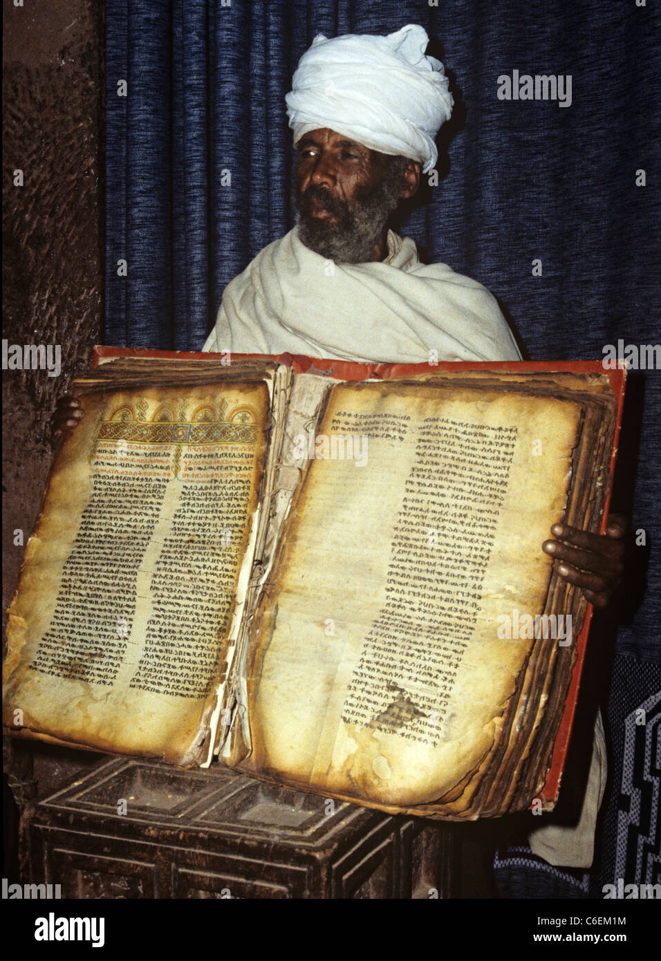 Priest holds an old parchment bible written in geeze ancient language 