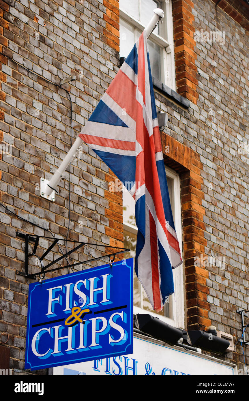 British Union Jack flying above a sign for a Fish and Chip shop Stock Photo