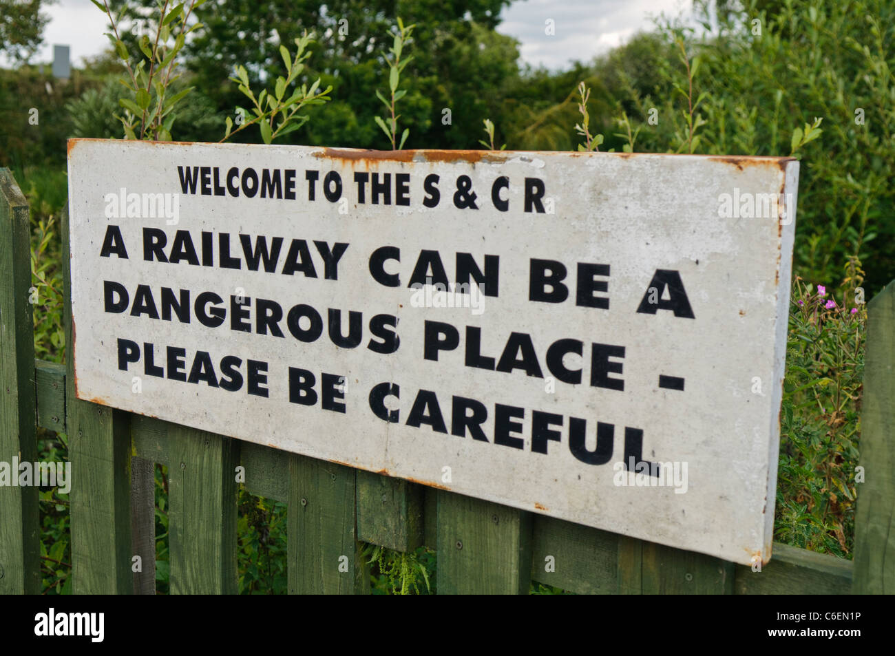Sign warning passengers and visitors to be careful near the railway tracks Stock Photo