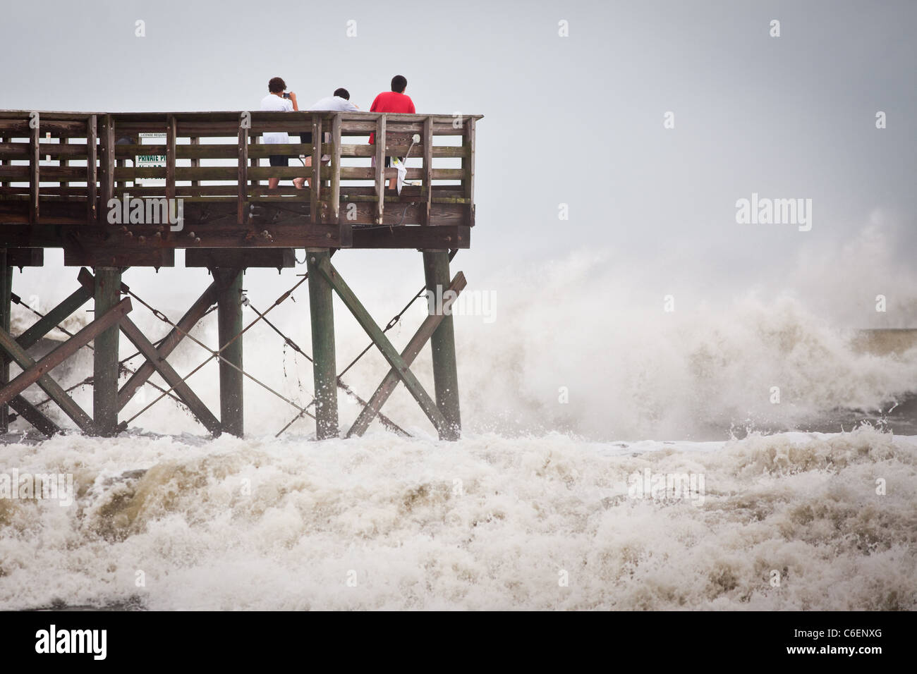 Onlookers watch the massive waves caused by passing Hurricane Irene on August 26, 2011 in Isle of Palms, South Carolina Stock Photo