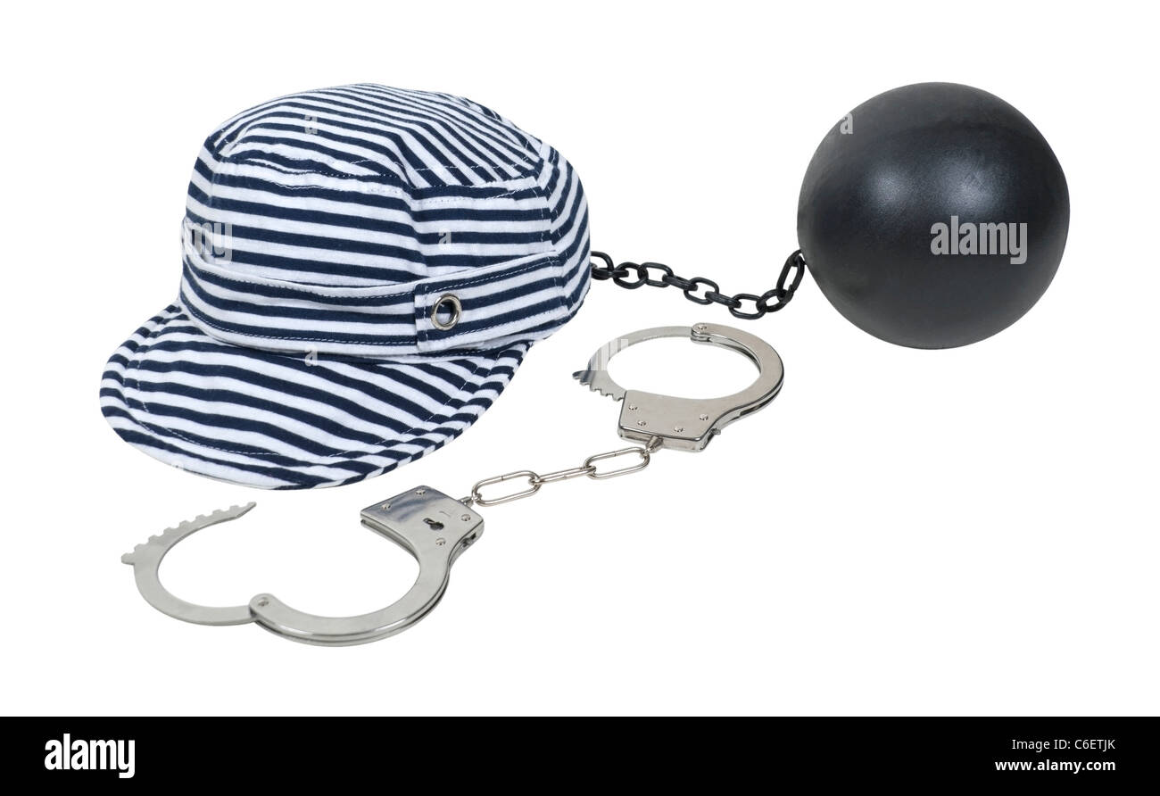 Jailbird striped hat worn in vintage jails as part of the uniform with a pair of handcuffs and ball and chain Stock Photo