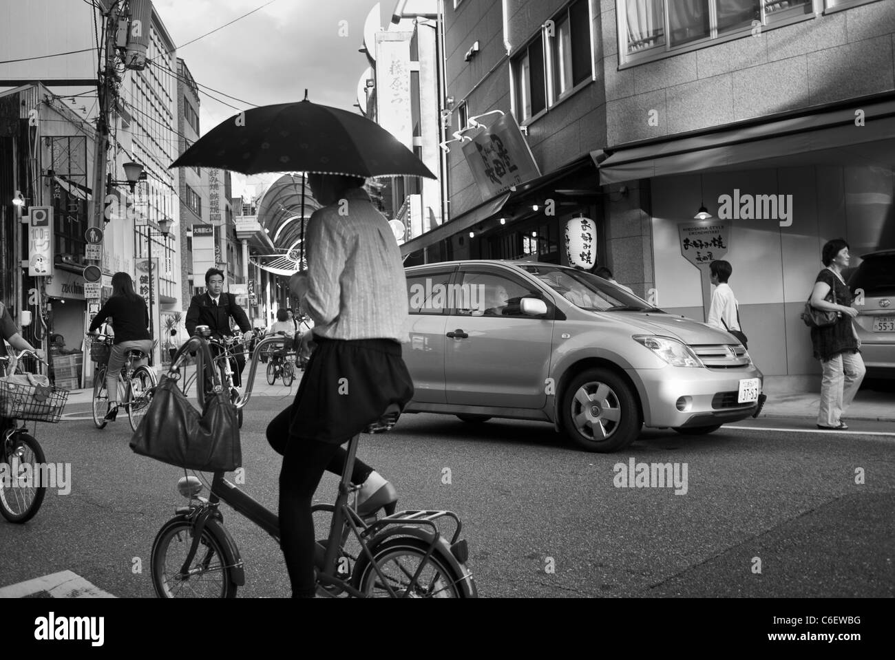 Woman on a Bike Holding an Umbrella, Hiroshima, Japan Stock Photo Alamy