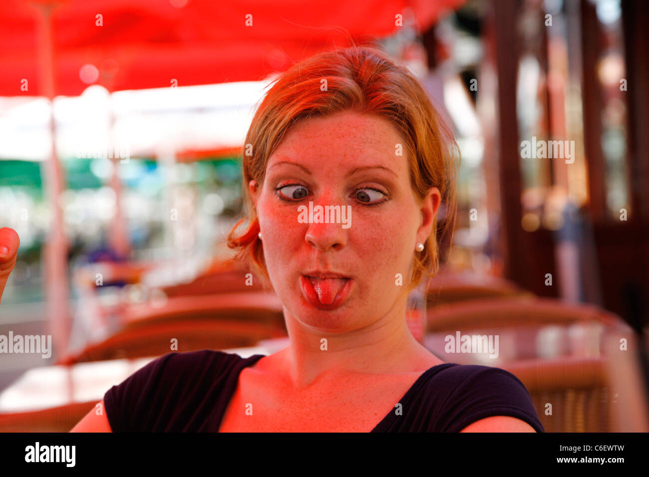Woman pulling tongue out with eyes crossed Stock Photo