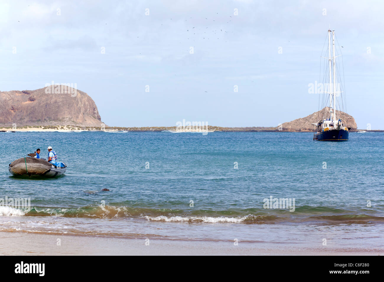 Yacht crew in panga waiting for passengers, with yacht in the background, Punta Pitt, Espanola Island, Galapagos Stock Photo