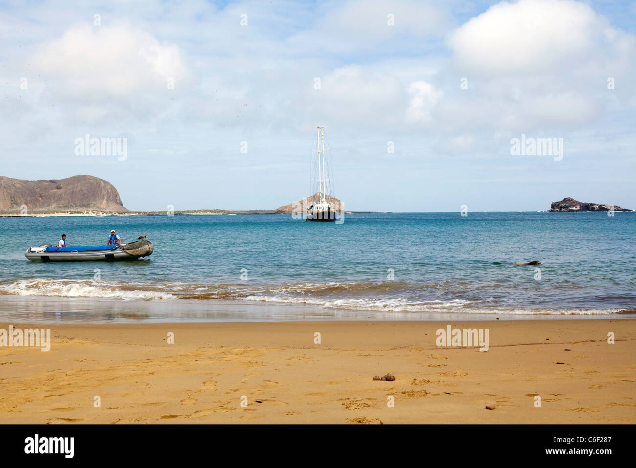 Yacht crew in panga waiting for passengers, with yacht in the background, Punta Pitt, Espanola Island, Galapagos Stock Photo