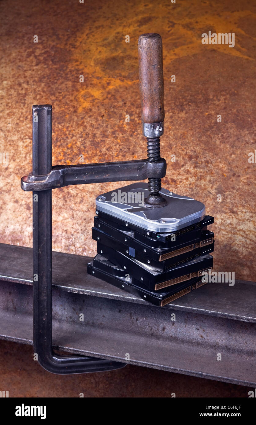 Clamp Pressing On Stack Of Hard Drives. Rusty Background Stock