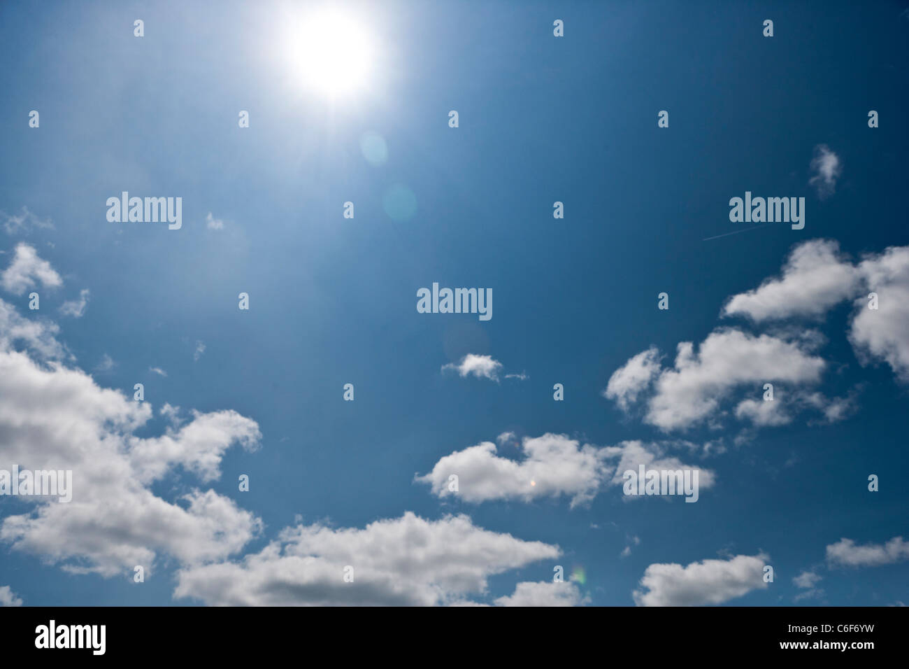 Blue sky with sun and cumulus clouds Stock Photo - Alamy