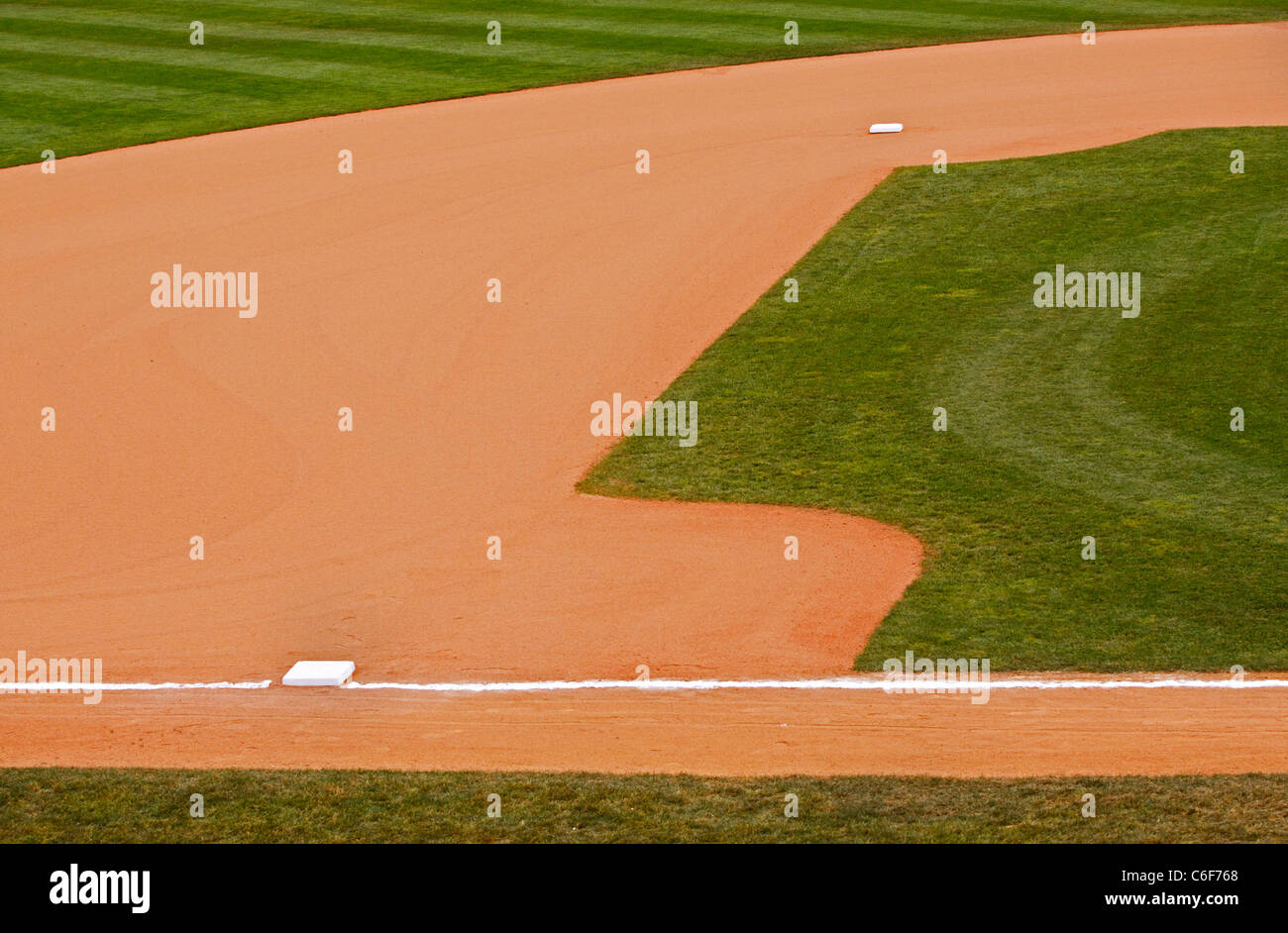 A portion of an baseball park's dirt and grass infield showing second and third bases. Stock Photo