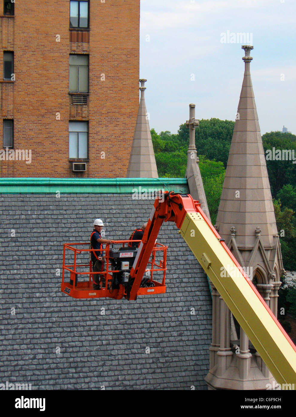 Man on red crane with church steeples. Central Park West.NYC Stock Photo