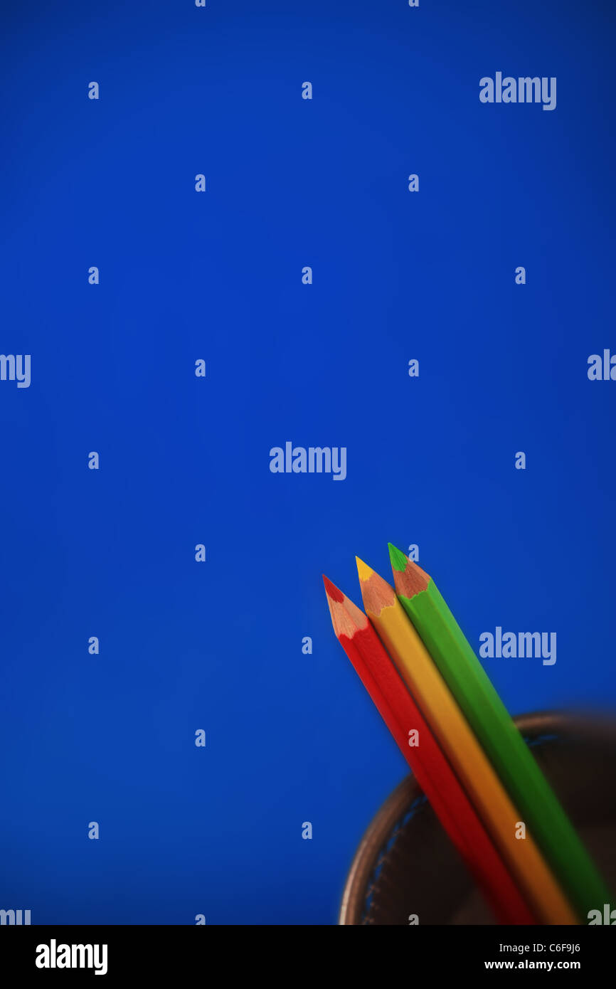 Red Yellow and Green Pencils on a blue background. Stock Photo