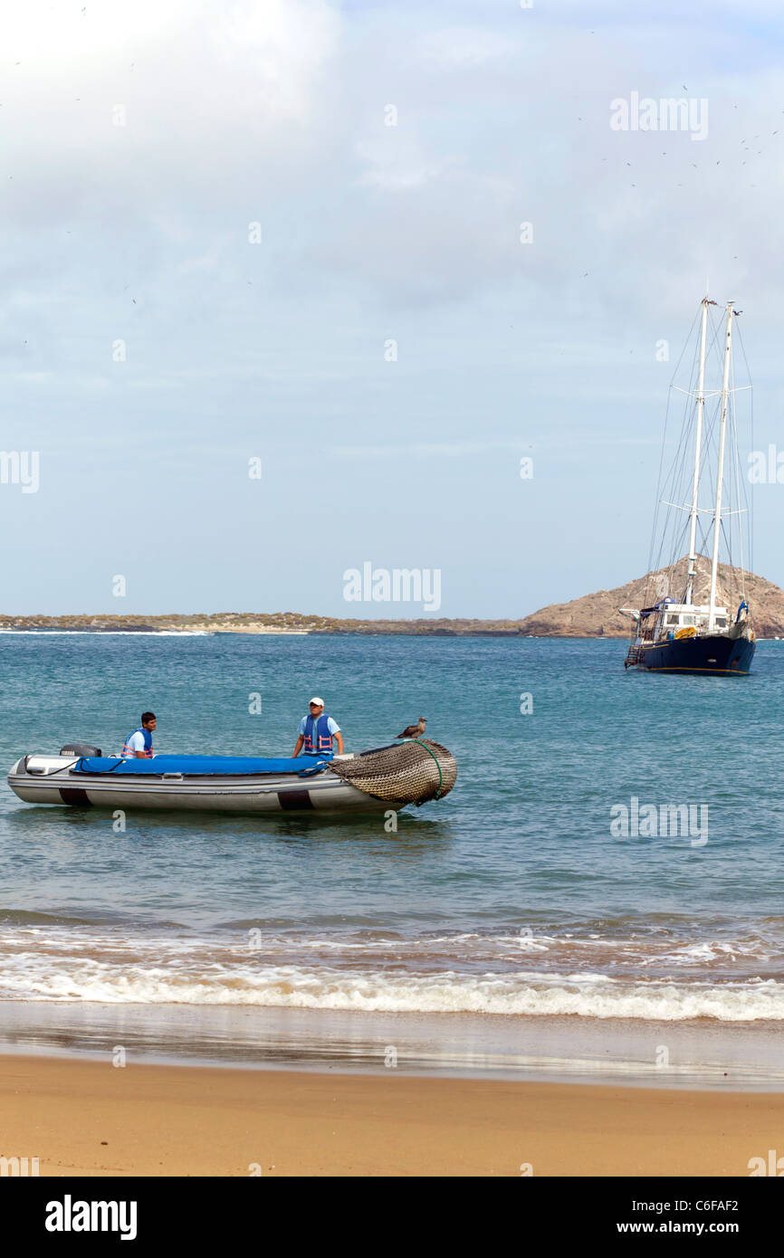 Yacht crew in panga waiting for passengers, with yacht in the background, Punta Pitt, Espanola Island, Galapagos Stock Photo