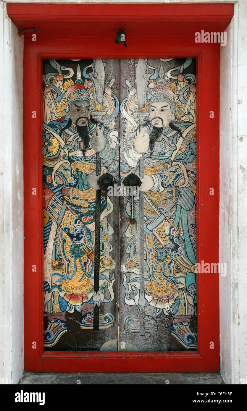 red framed temple door with painted Asian warriors Stock Photo