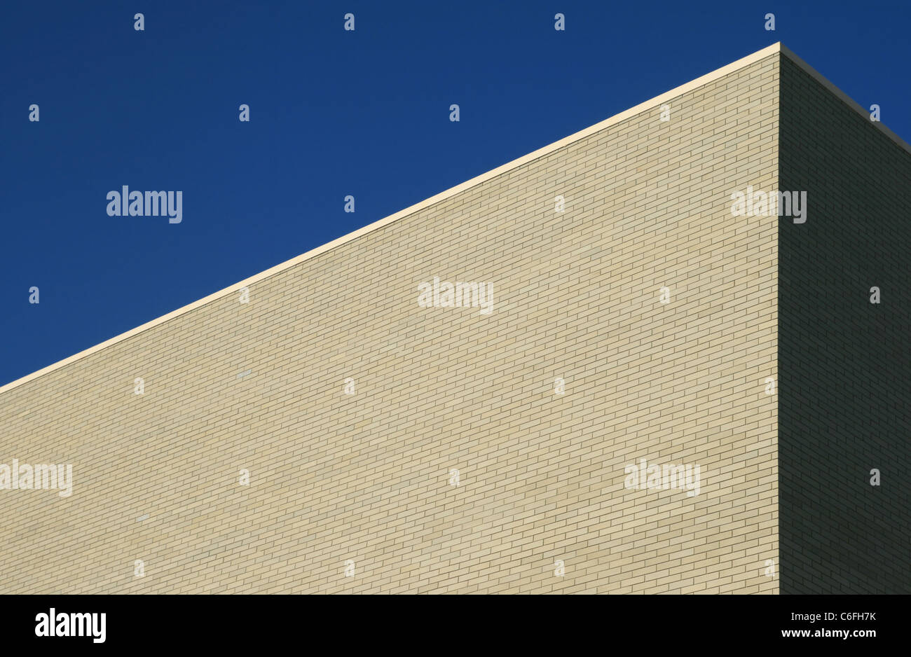 corner of large gray building with blue sky above Stock Photo
