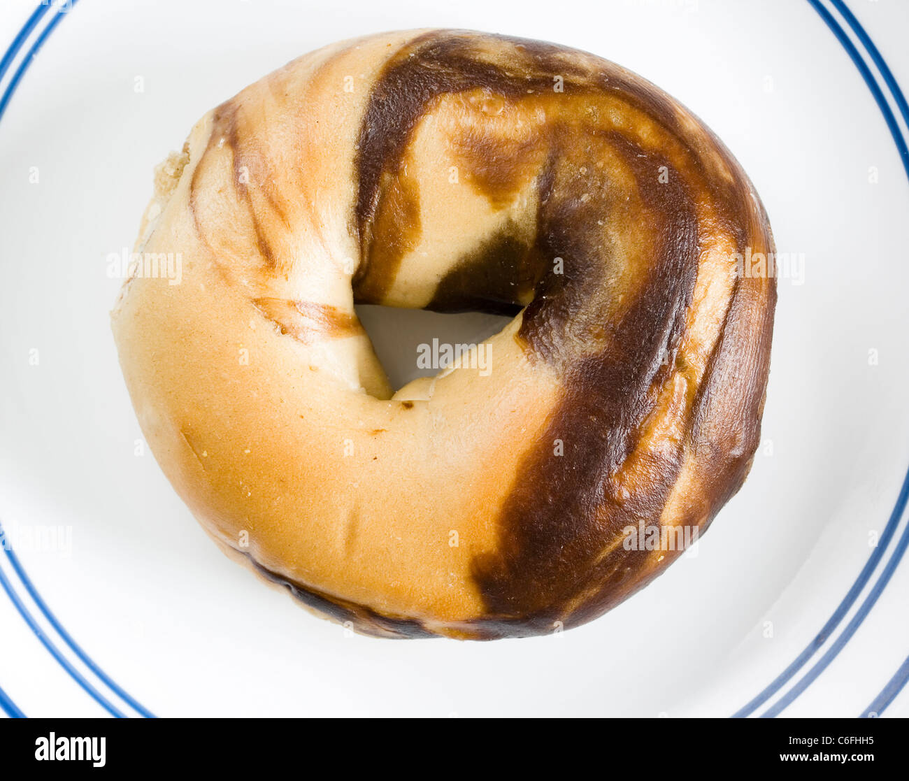 marbled rye bagel on a white and blue plate Stock Photo