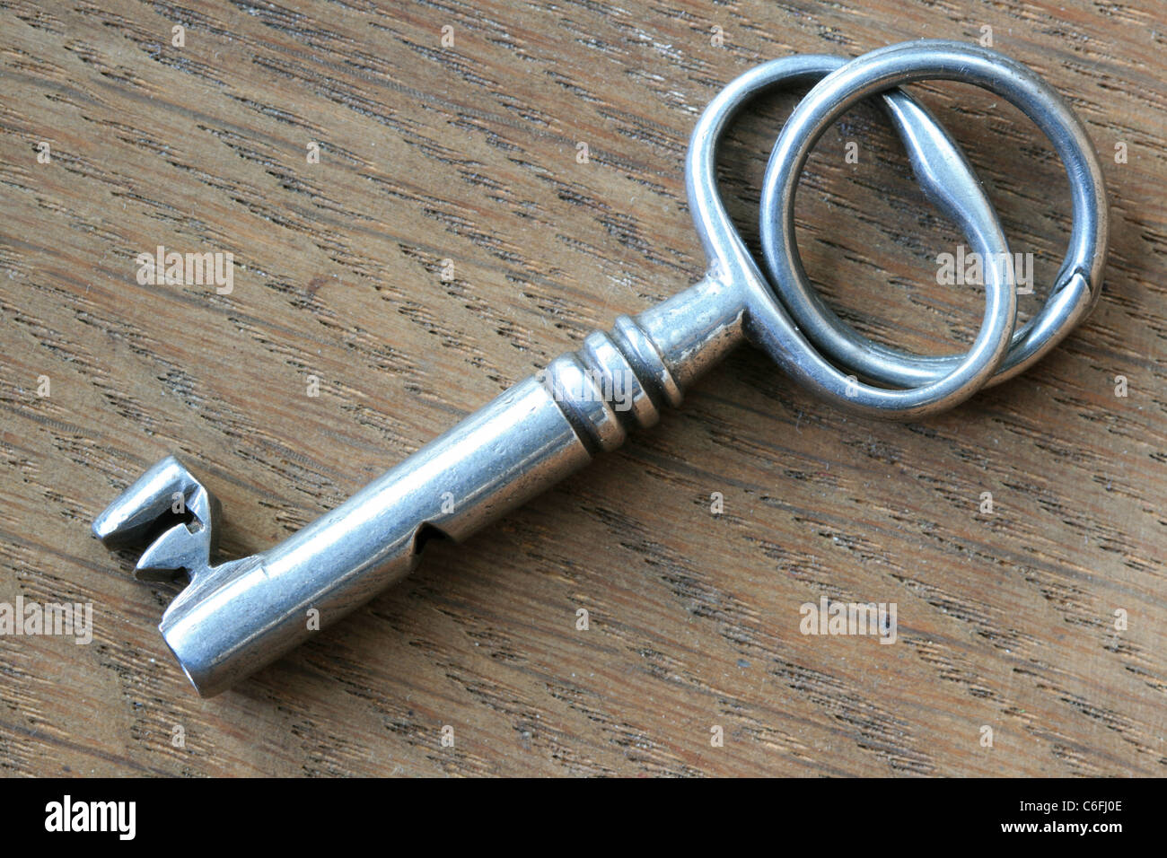 close up of antique silver key on walnut wood background Stock Photo