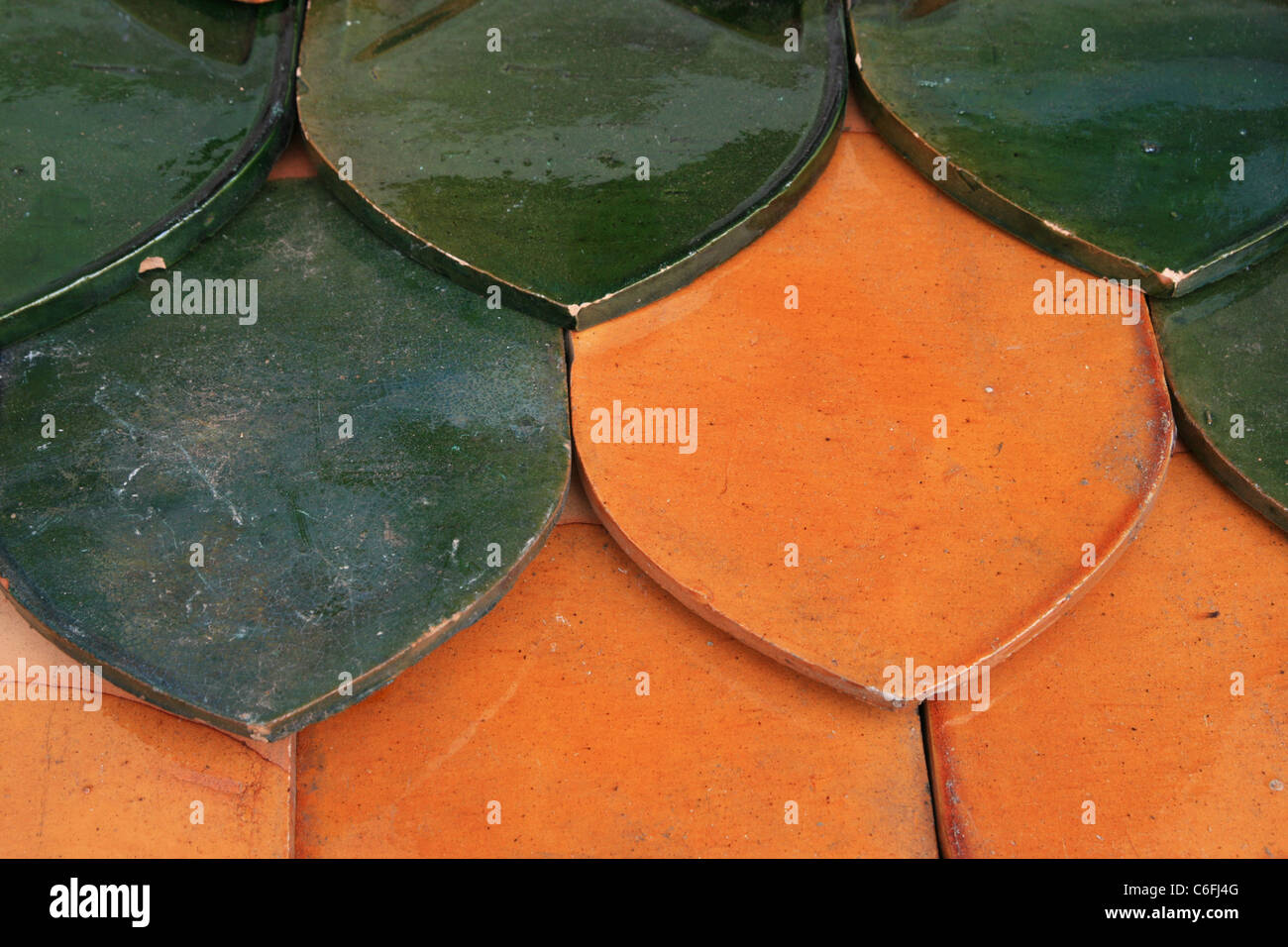 orange and green glazed ceramic tile roof detail from temple Stock Photo