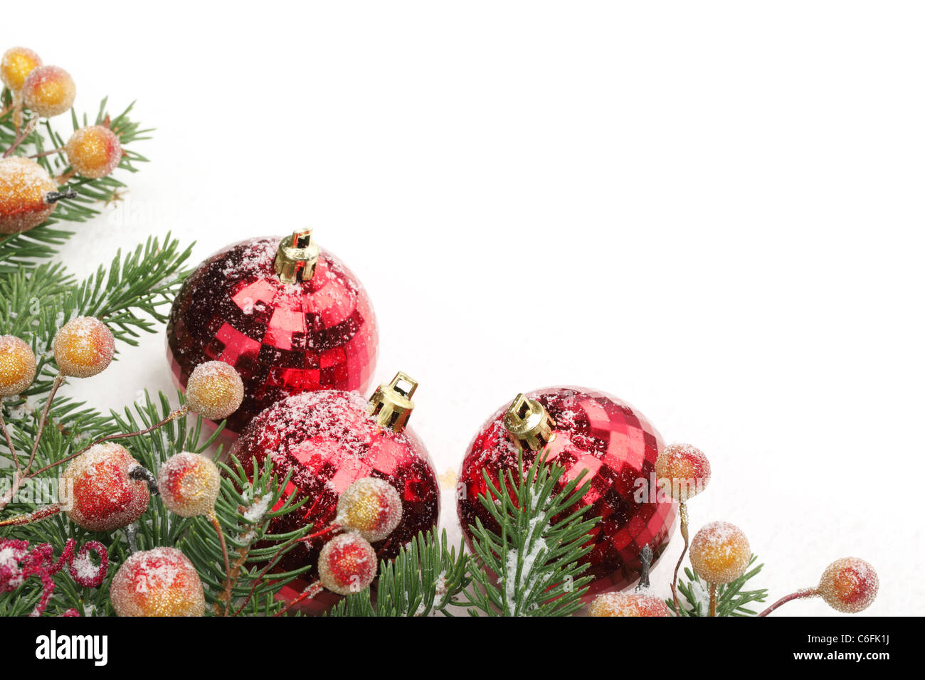 Pine branches, berries and balls with snow for Christmas border. Stock Photo