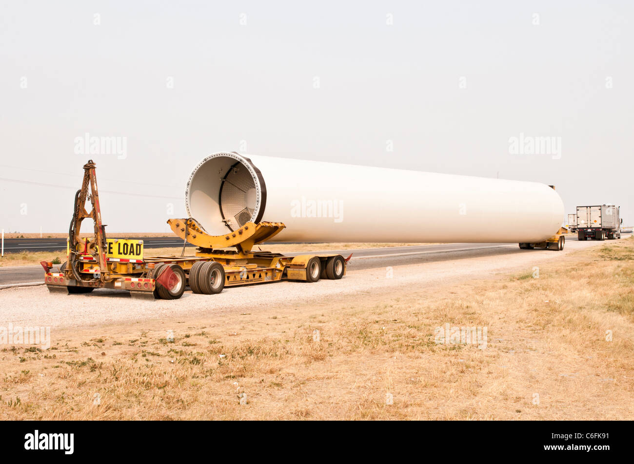 A tower section for a horizontal-axis wind turbine is delivered to a construction site near Amarillo, Texas. Stock Photo