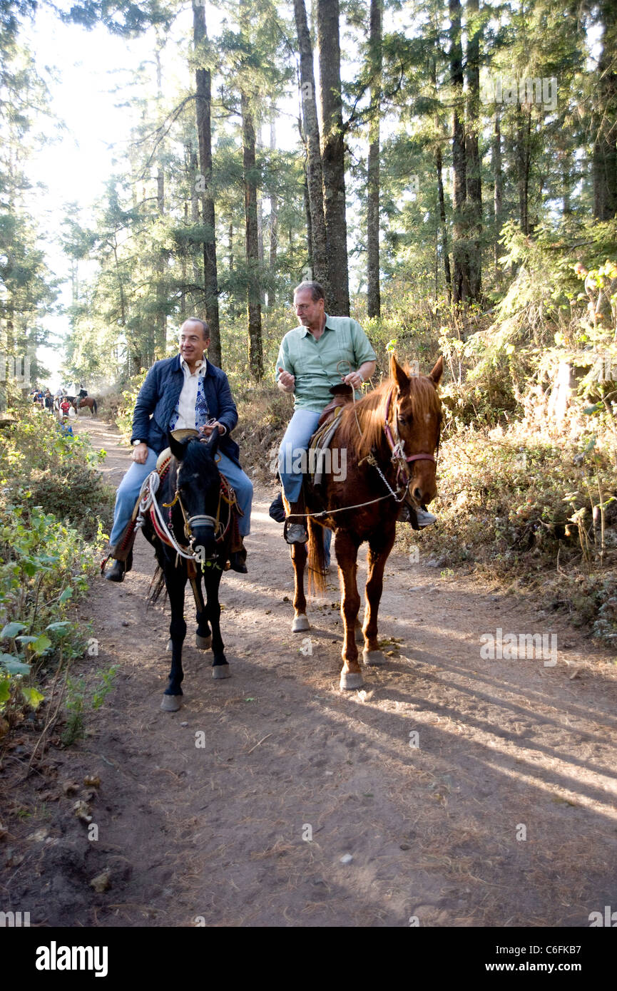 President Calderon of Mexico and Peter Greenberg on horseback at the Mariposa Biosphere Butterfly Reserve  in Michoacan, Mexico Stock Photo