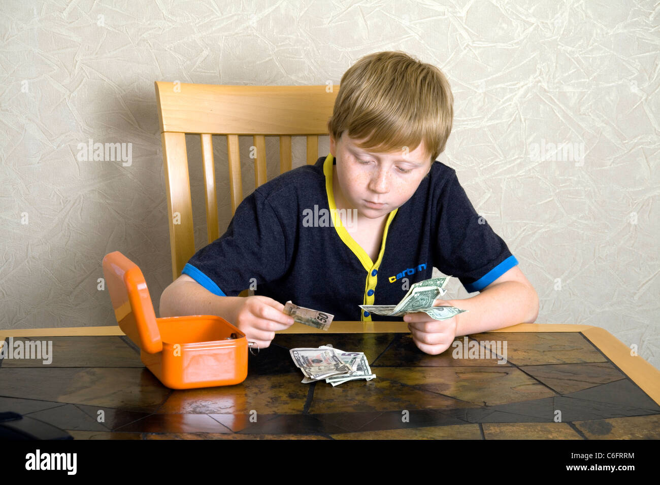 A 12 year old boy counting out American Dollars Stock Photo