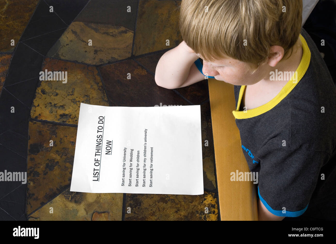 A 12 year old boy looks at a list of things he should start doing now. (See 'more information' Stock Photo