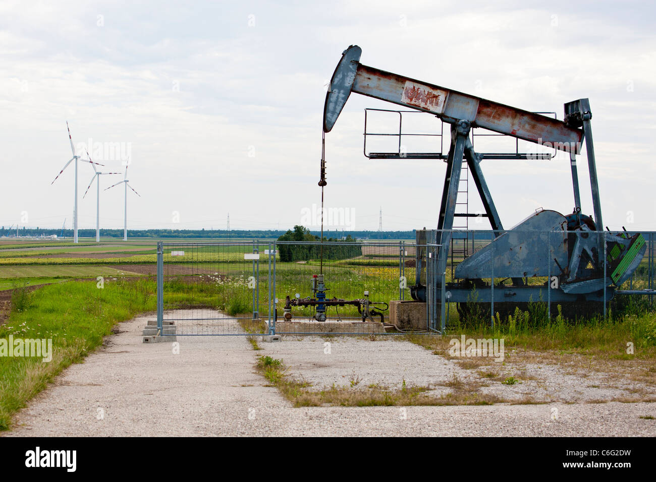 Crude oil pump with wind turbines in the background Stock Photo Alamy