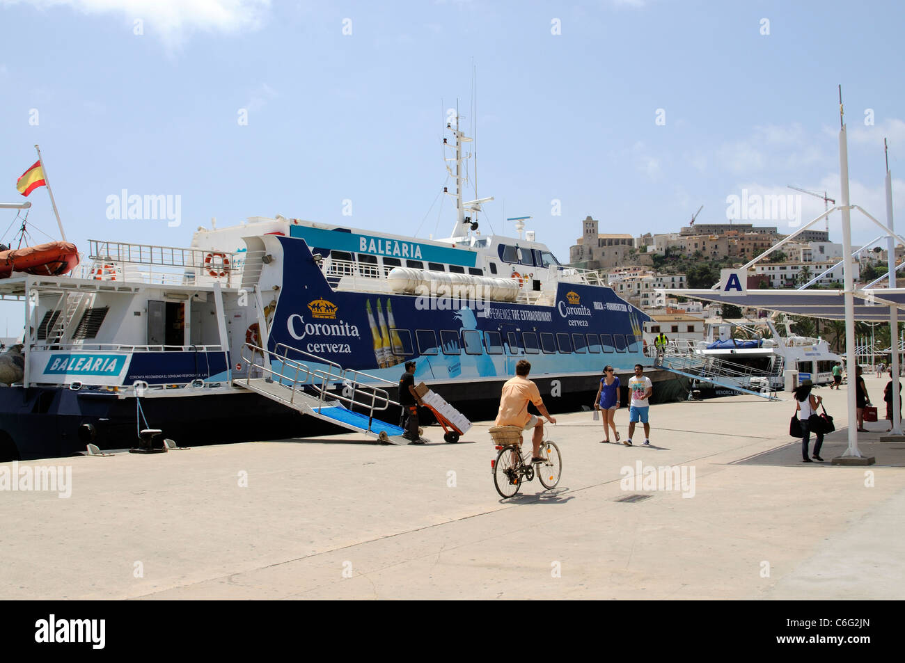 Inter island ferries berthed on the quayside overlooked by the historic old town of Eivissa on the Spanish Island of Ibiza Stock Photo
