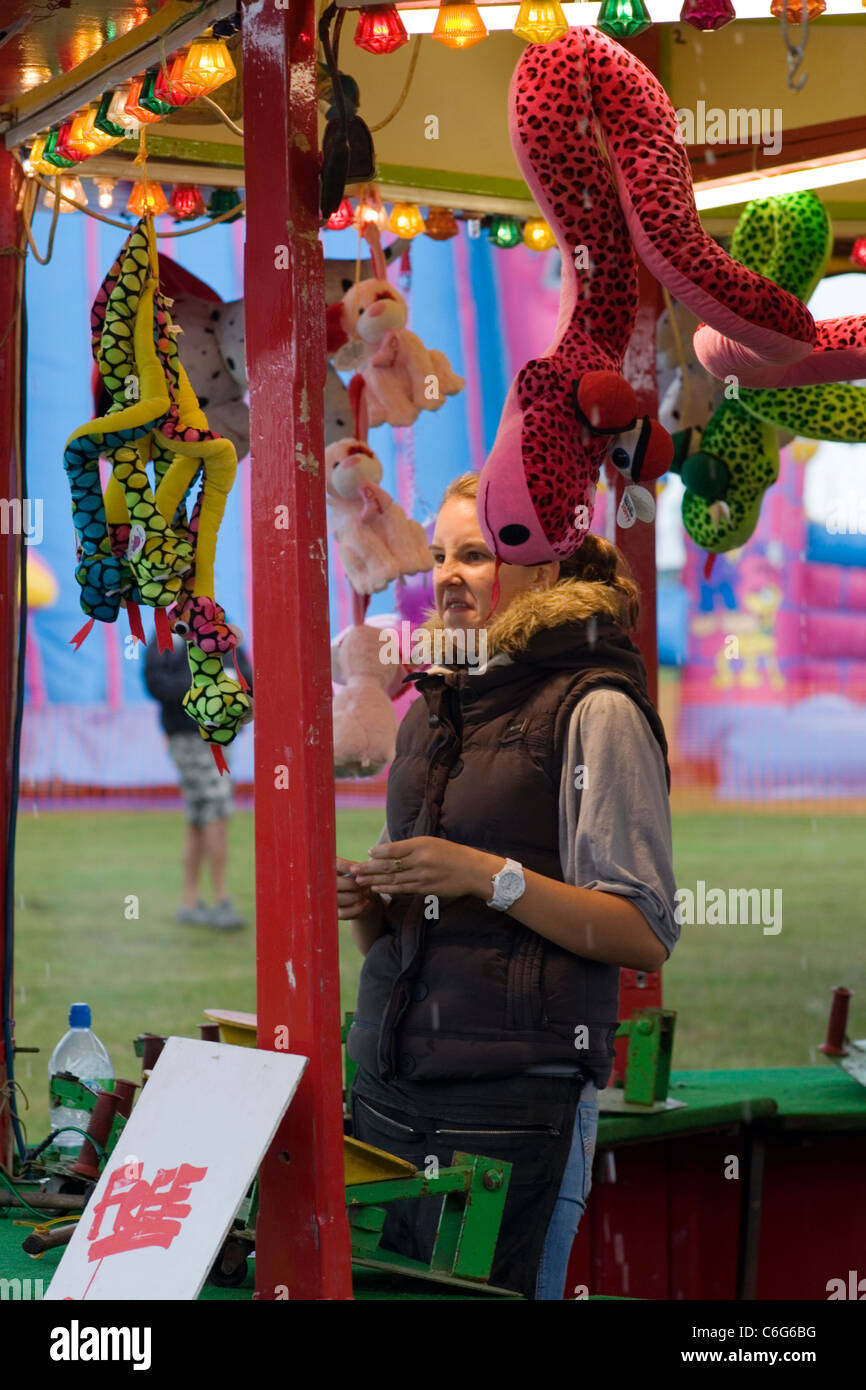 fairground woman looking dismayed at the  downpour of rain at southsea kite festival Stock Photo