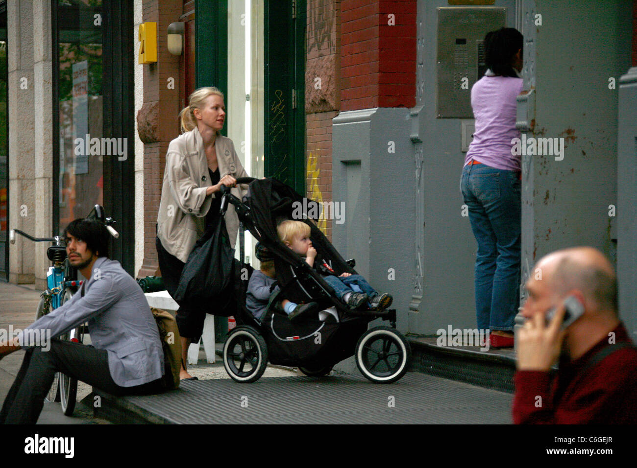 Naomi Watts, Alexander Pete Schreiber and Samuel Kai Schreiber Naomi Watts pushing her children in a stroller while walking in Stock Photo