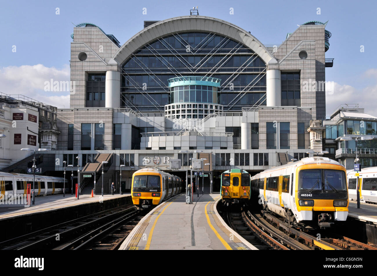 Embankment Place office building built above London Charing Cross railway train station platform with passenger trains at platforms  England UK Stock Photo