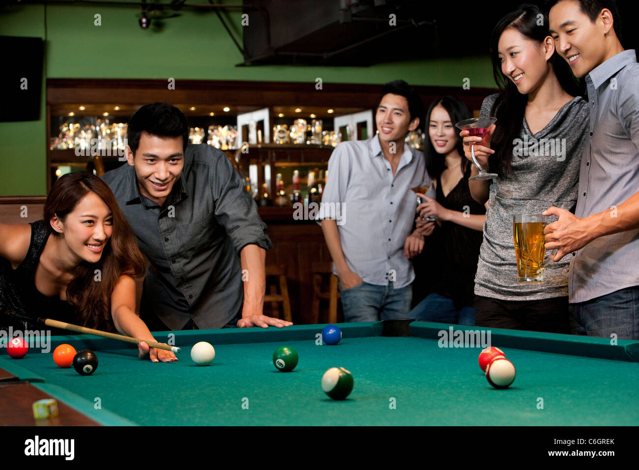 Billiards game. young friends playing pool together Stock Photo - Alamy