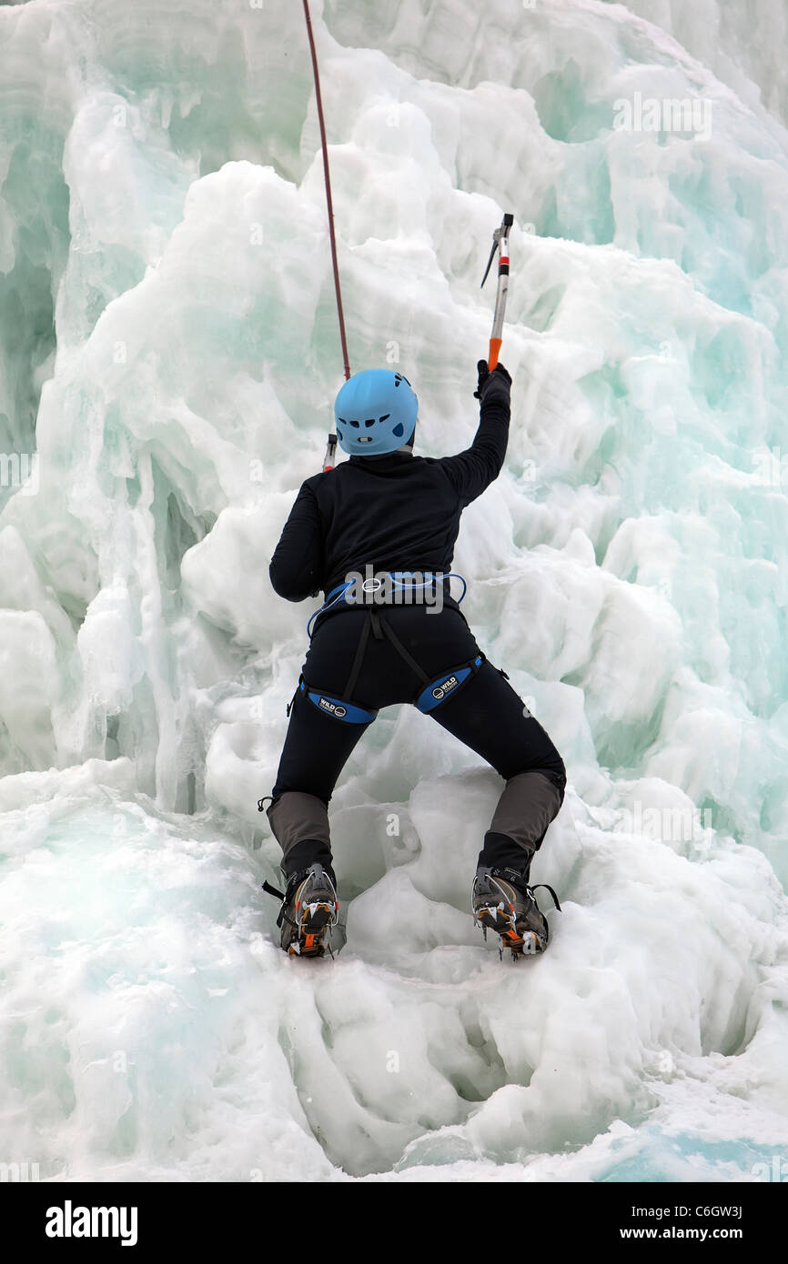 Young adult woman, ice climbing. Stock Photo