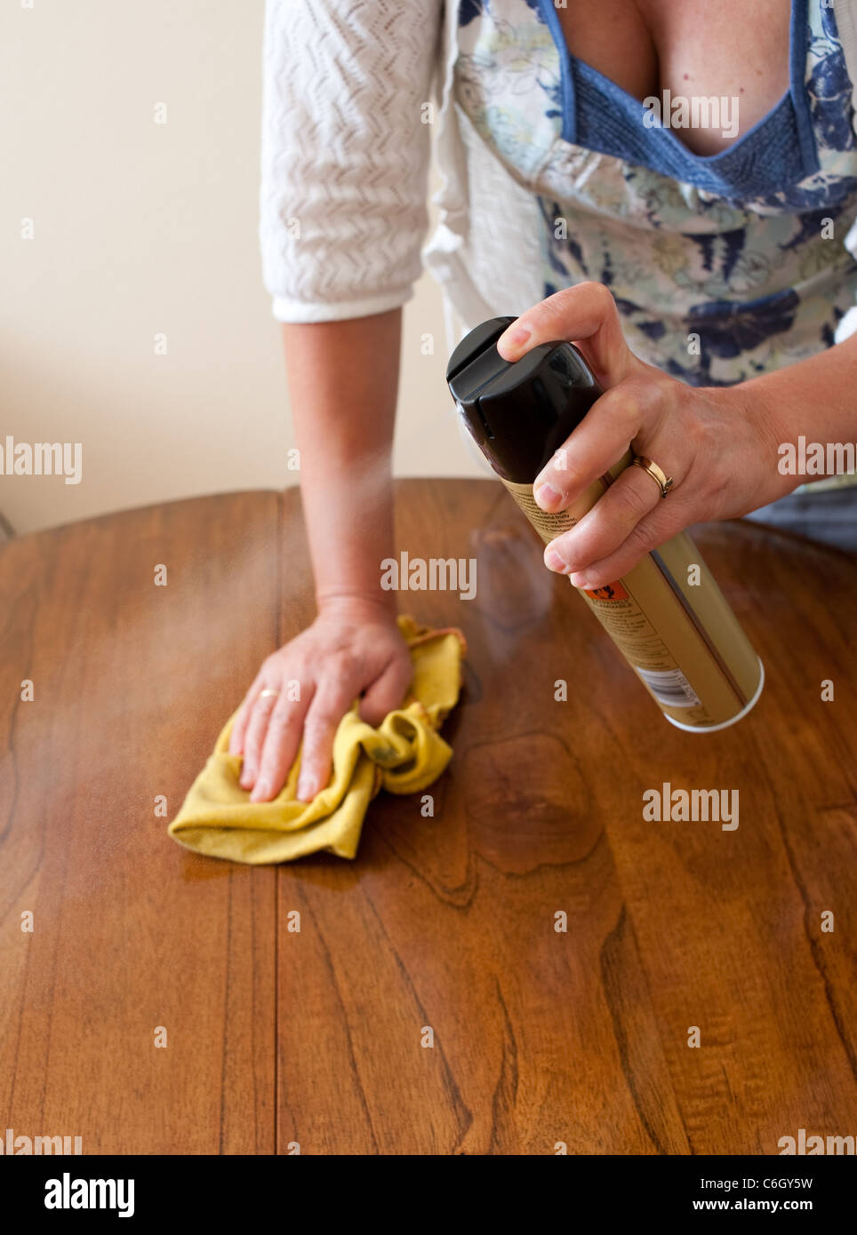 Woman polishing a wooden dining room table Stock Photo Alamy