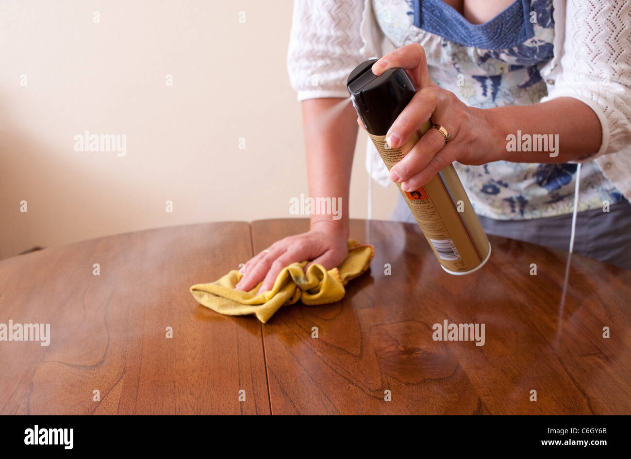 Woman polishing a wooden dining room table Stock Photo Alamy