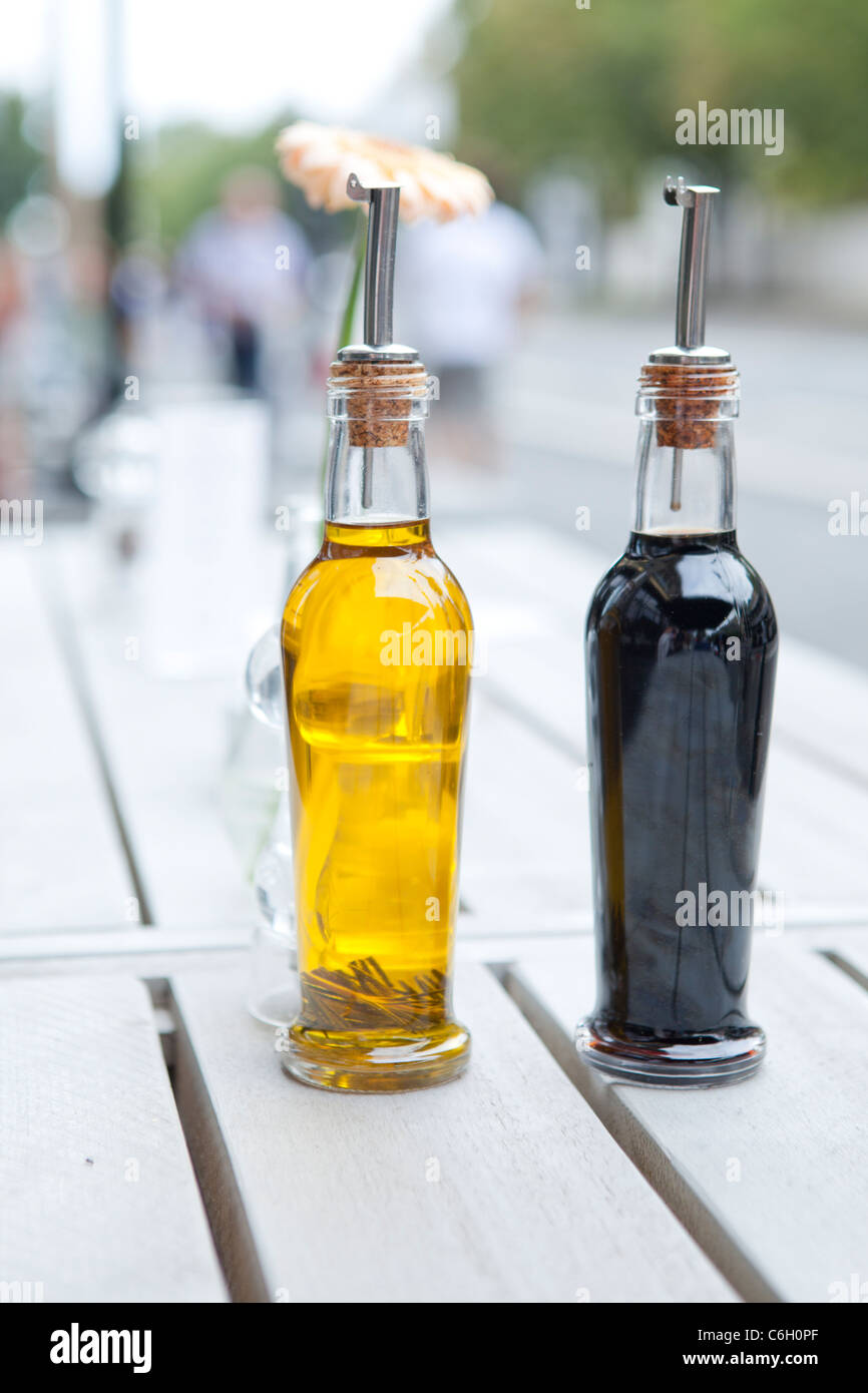 OIL AND VINEGAR BOTTLES ON TABLE OUTDOOR Stock Photo