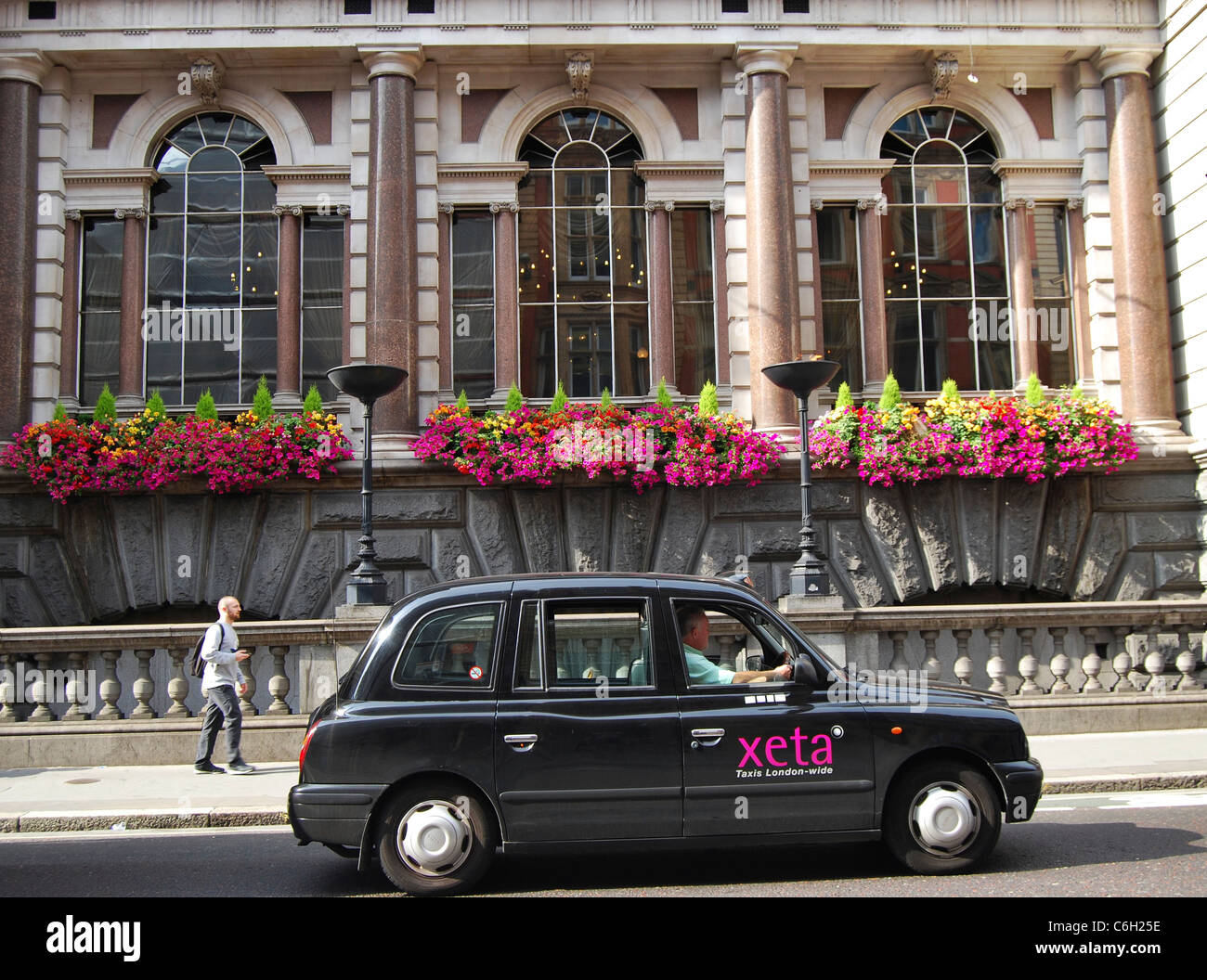 Traditional London black taxi passing the Fuller's Ale & Pie House pub