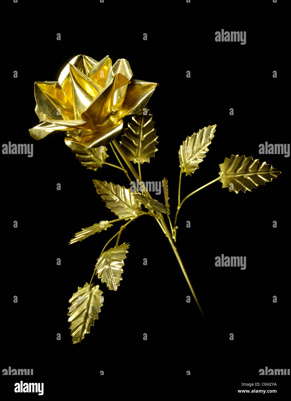 Shiny metal rose Flower made from brass Isolated on black background Stock Photo