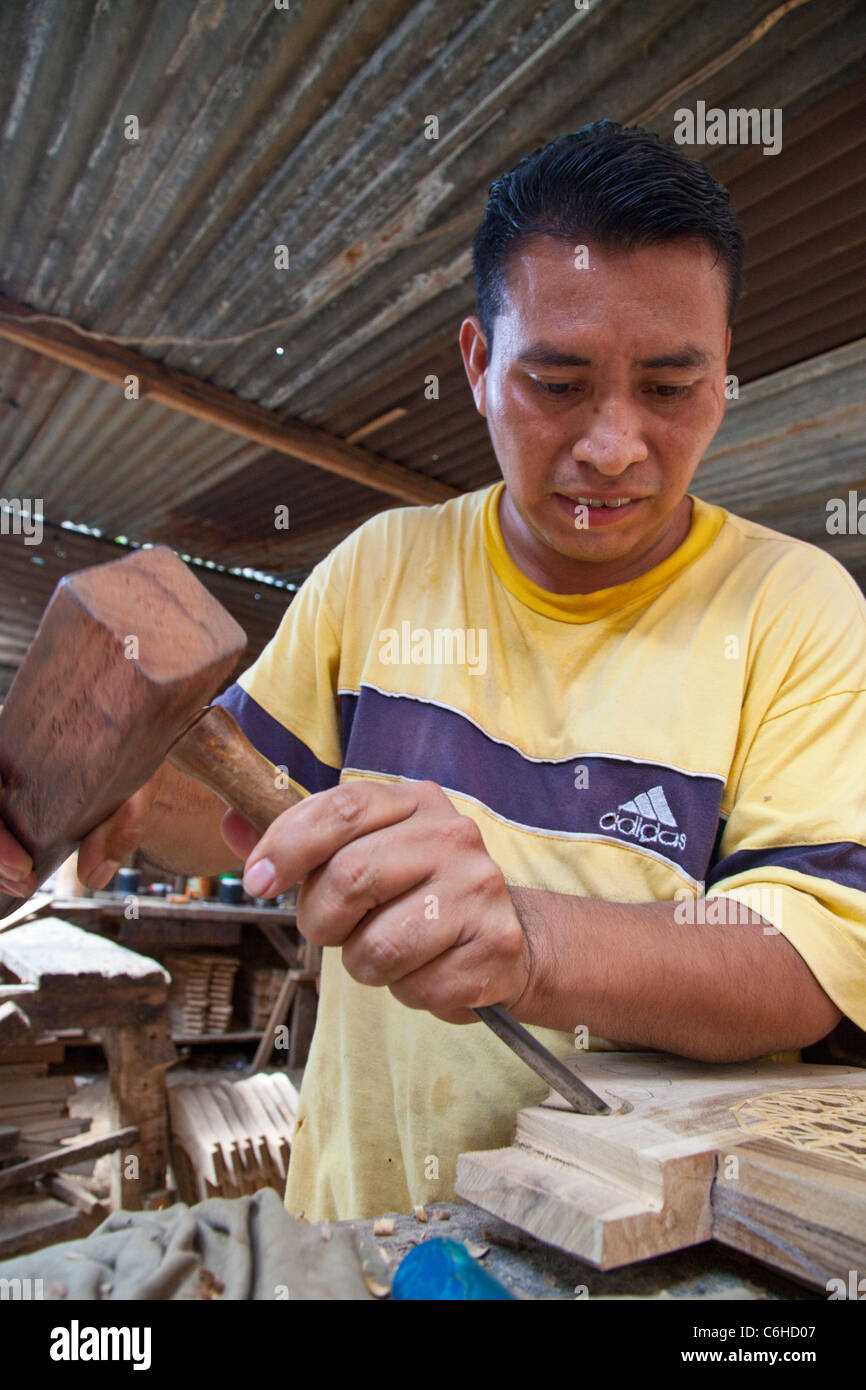 Craftsman carving design into wood furniture, San Salvador, El Salvador