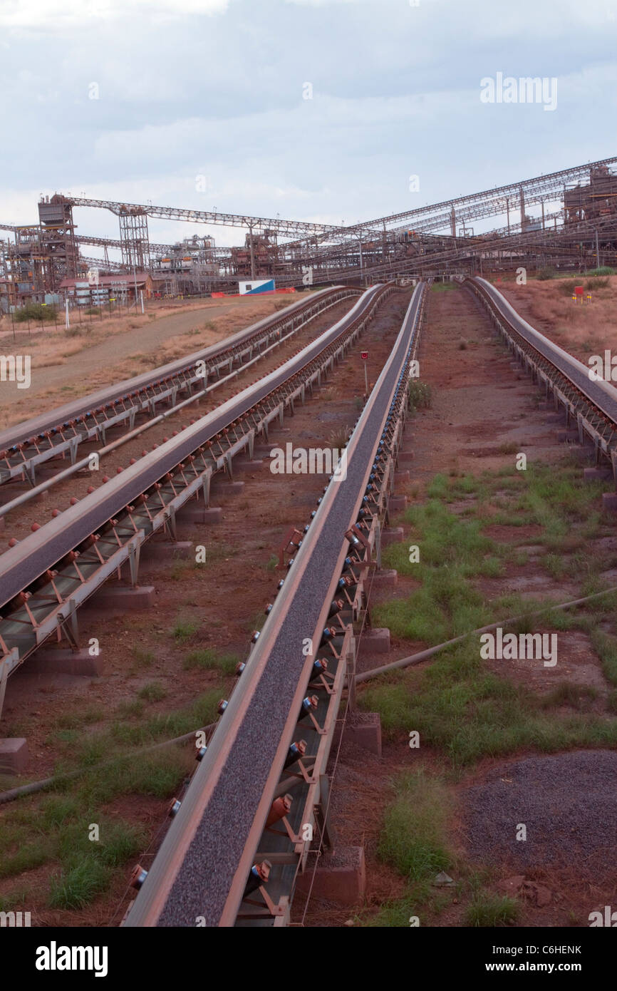 Conveyor belts carrying crushed ore towards a railway loading terminal at an Iron Ore mine near Sishen Stock Photo