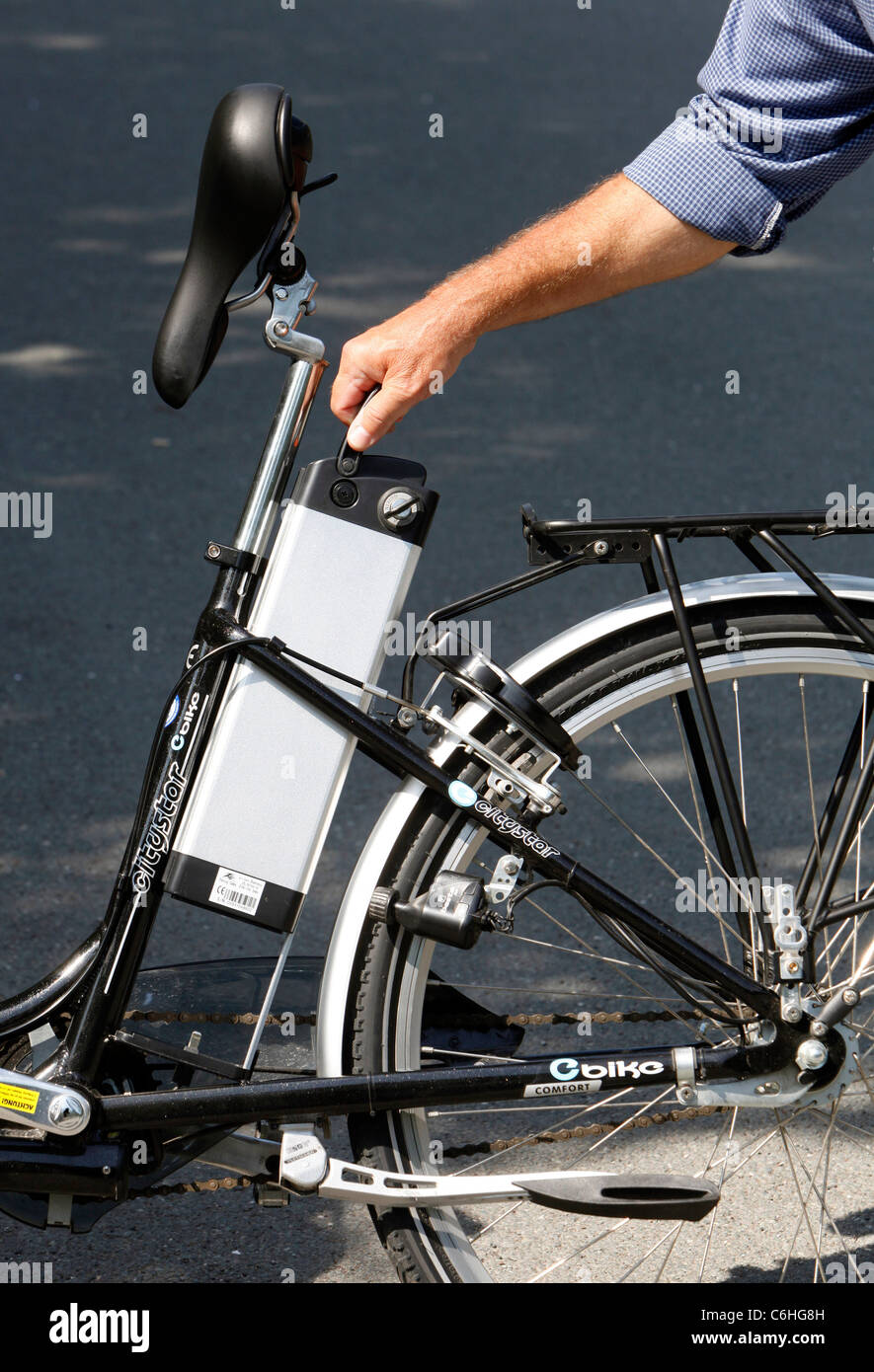 Girl changing battery on electric bicycle, pedelec, ebike, e-bike, Dortmund, Germany Stock Photo