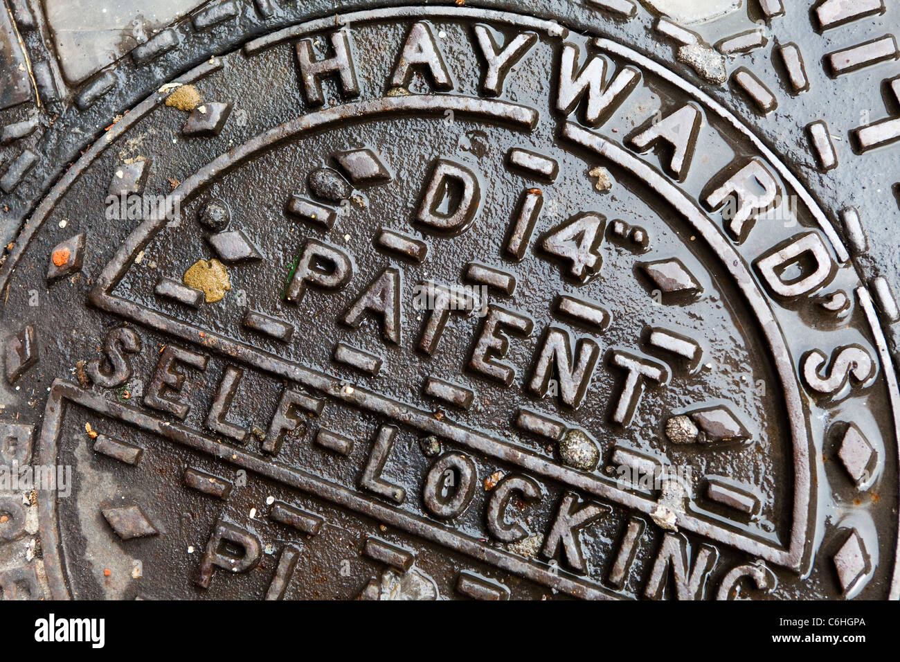 Manhole cover on a wet street, near Chancery Lane, London Stock Photo