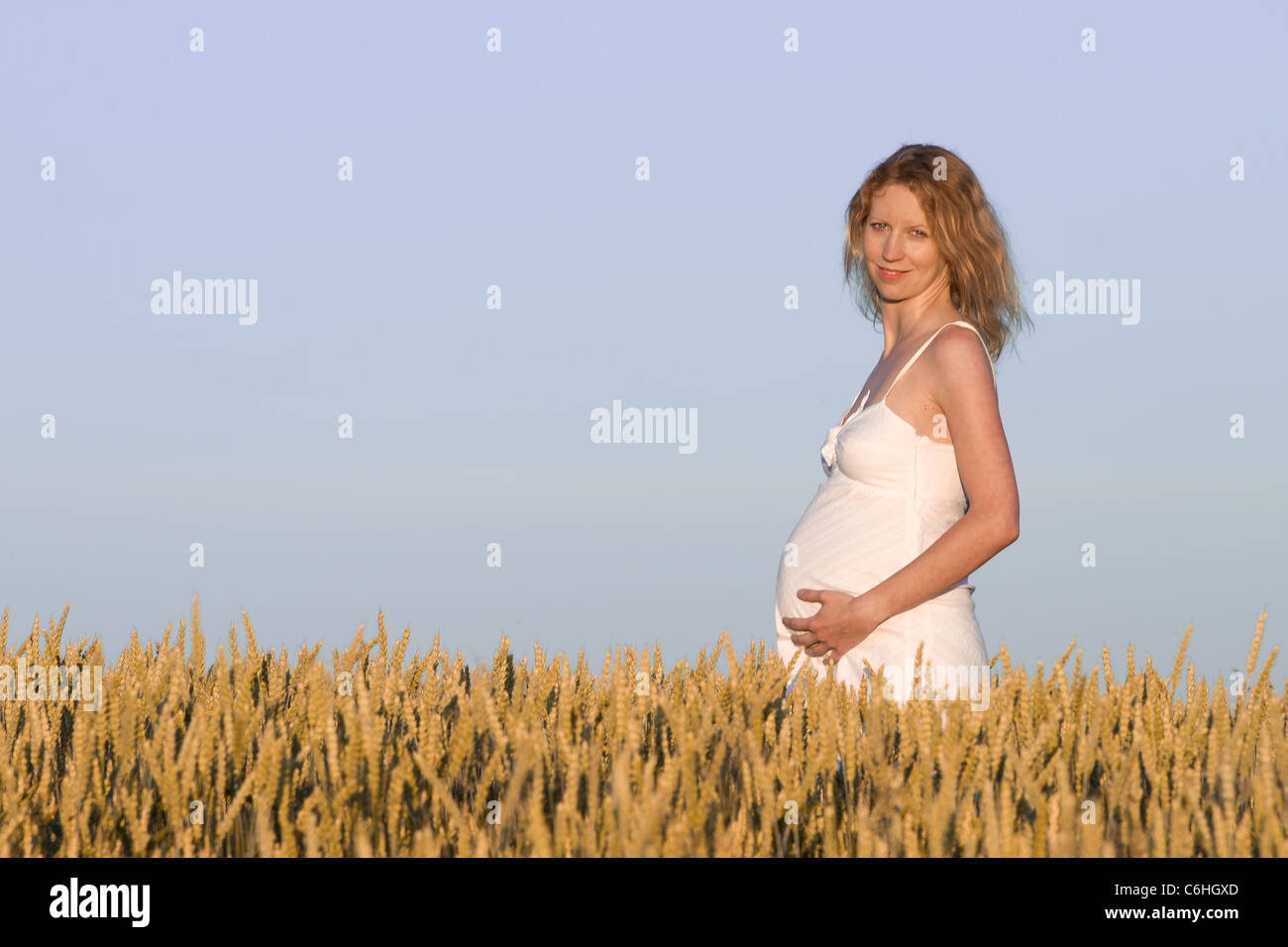 pregnant woman in white dress relaxing outdoors Stock Photo - Alamy
