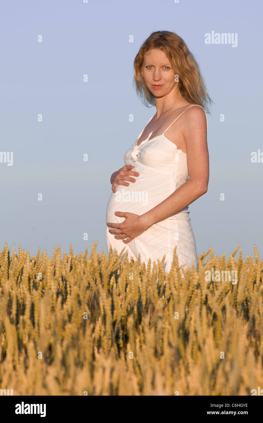 pregnant woman in white dress relaxing outdoors Stock Photo - Alamy