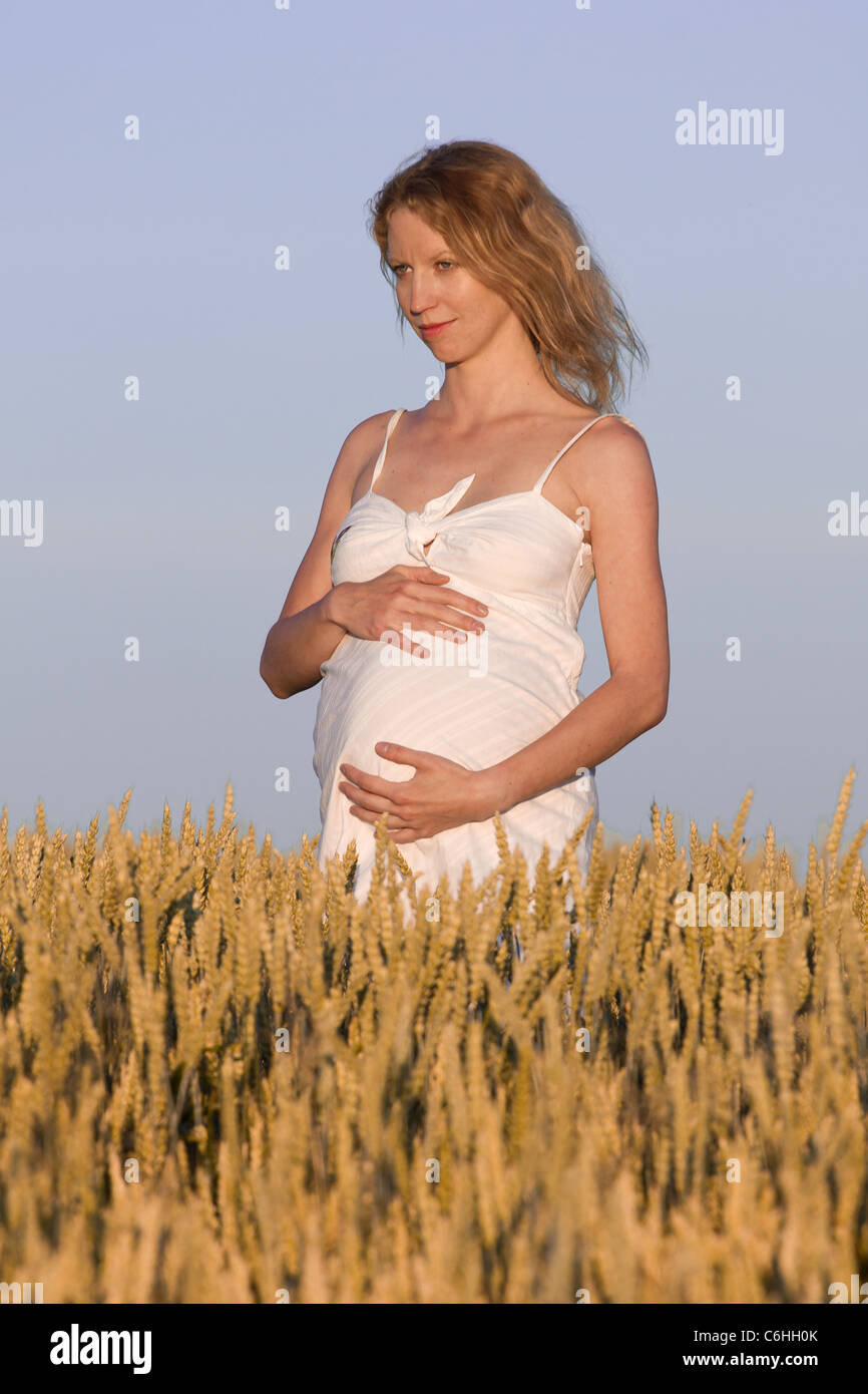 pregnant woman in white dress relaxing outdoors Stock Photo - Alamy