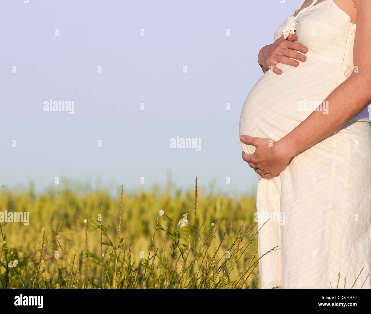 pregnant woman in white dress relaxing outdoors Stock Photo - Alamy