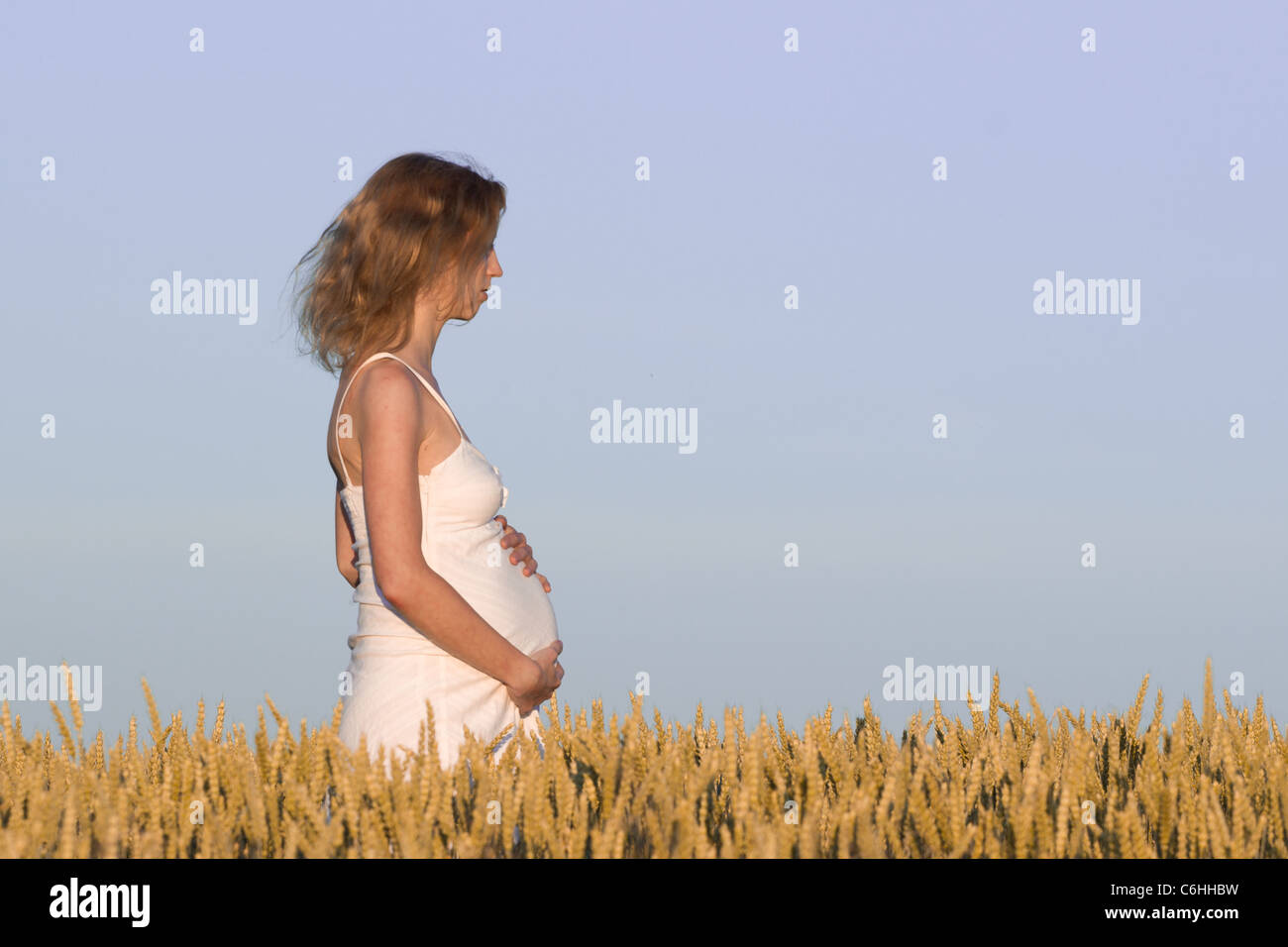 pregnant woman in white dress relaxing outdoors Stock Photo - Alamy