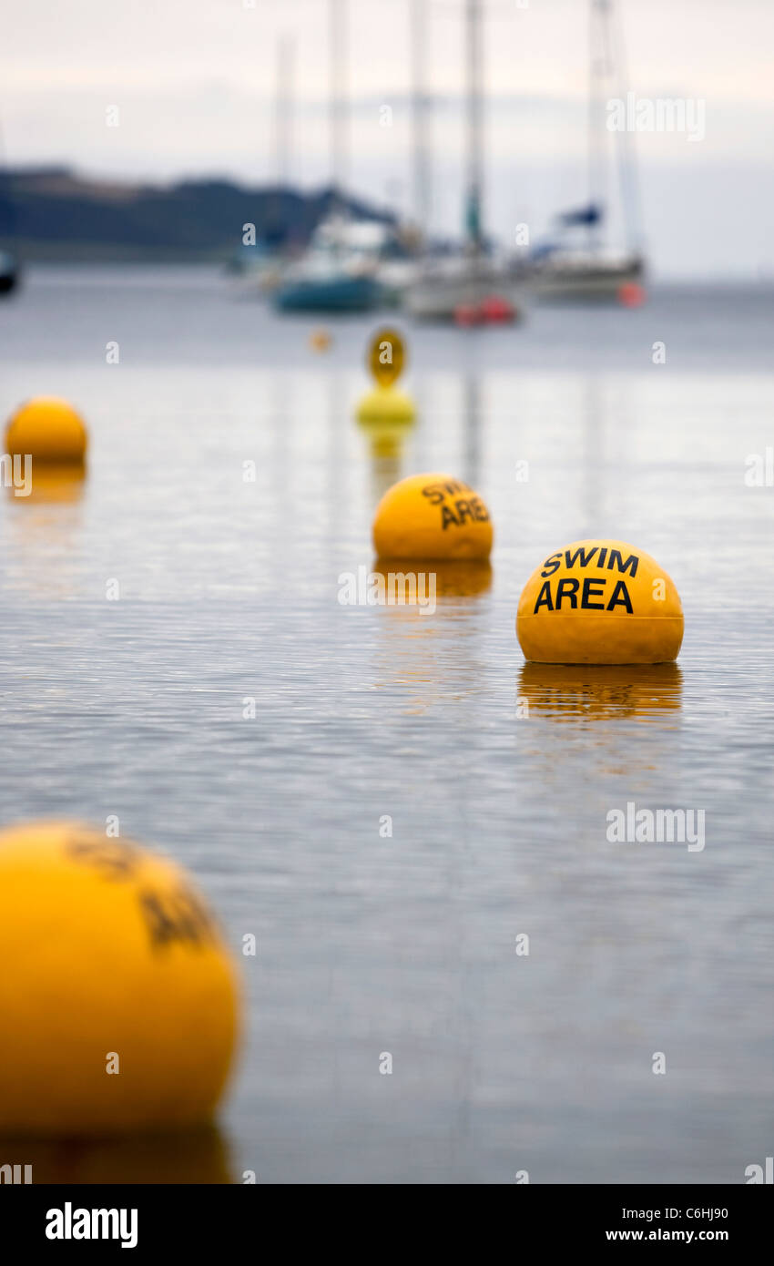 Yellow buoys in the sea at Loe Beach, Cornwall denoting the swim area Stock Photo